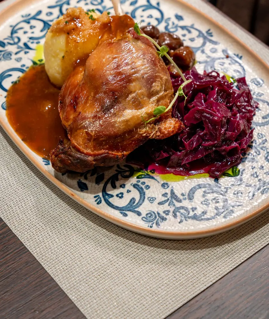 Knusprige Gänsekeule mit Kartoffelknödel, Apfel-Rotkohl und Maronen
