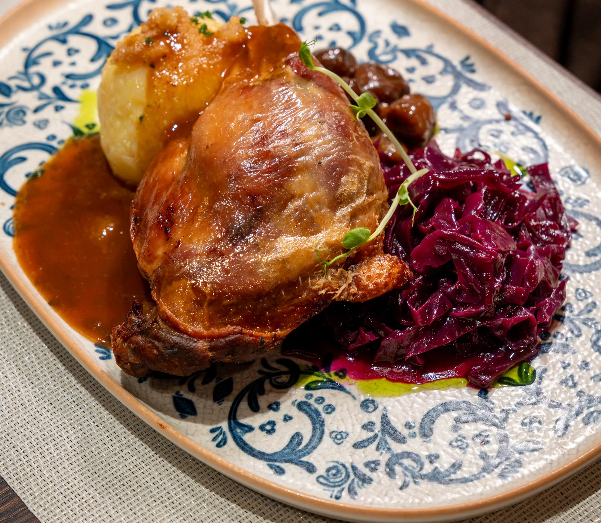 Knusprige Gänsekeule mit Kartoffelknödel, Apfel-Rotkohl und Maronen