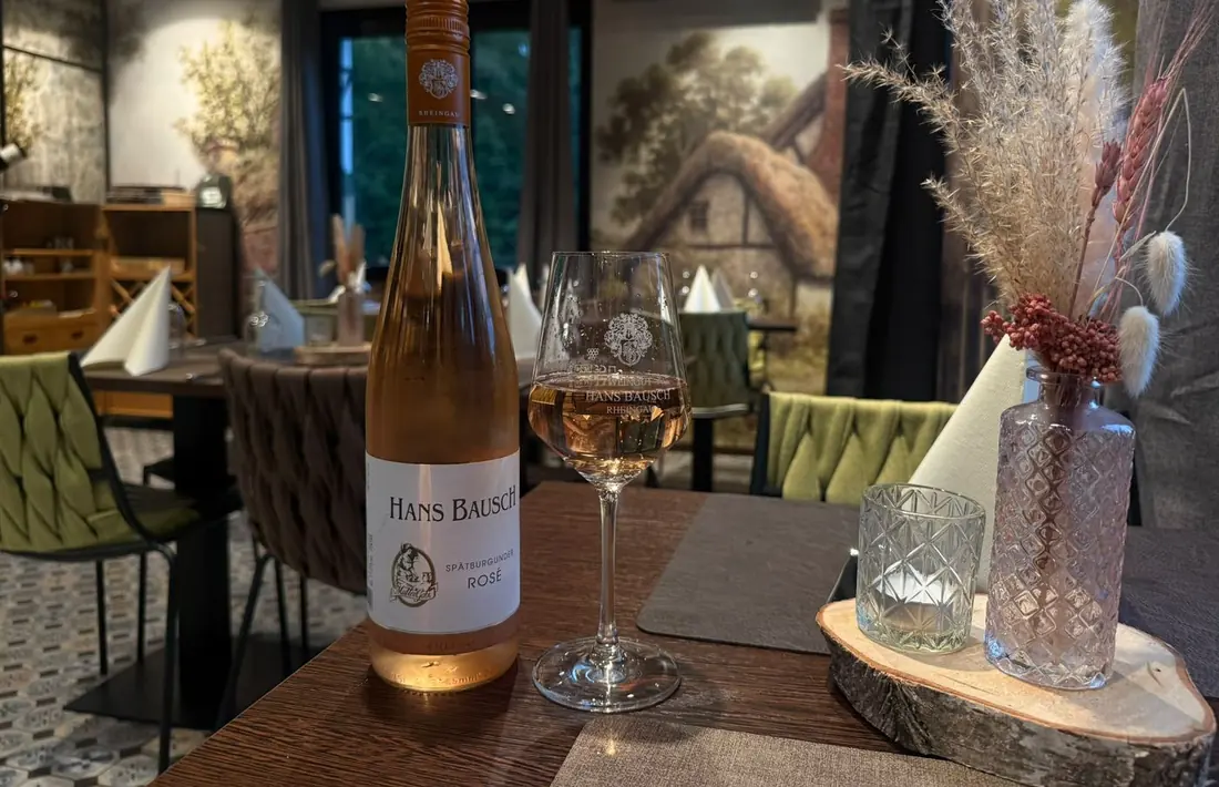 Flasche Spätburgunder Rosé von Hans Bausch mit Mutter-Gabi-Logo auf dem Etikett, daneben ein gefülltes Glas