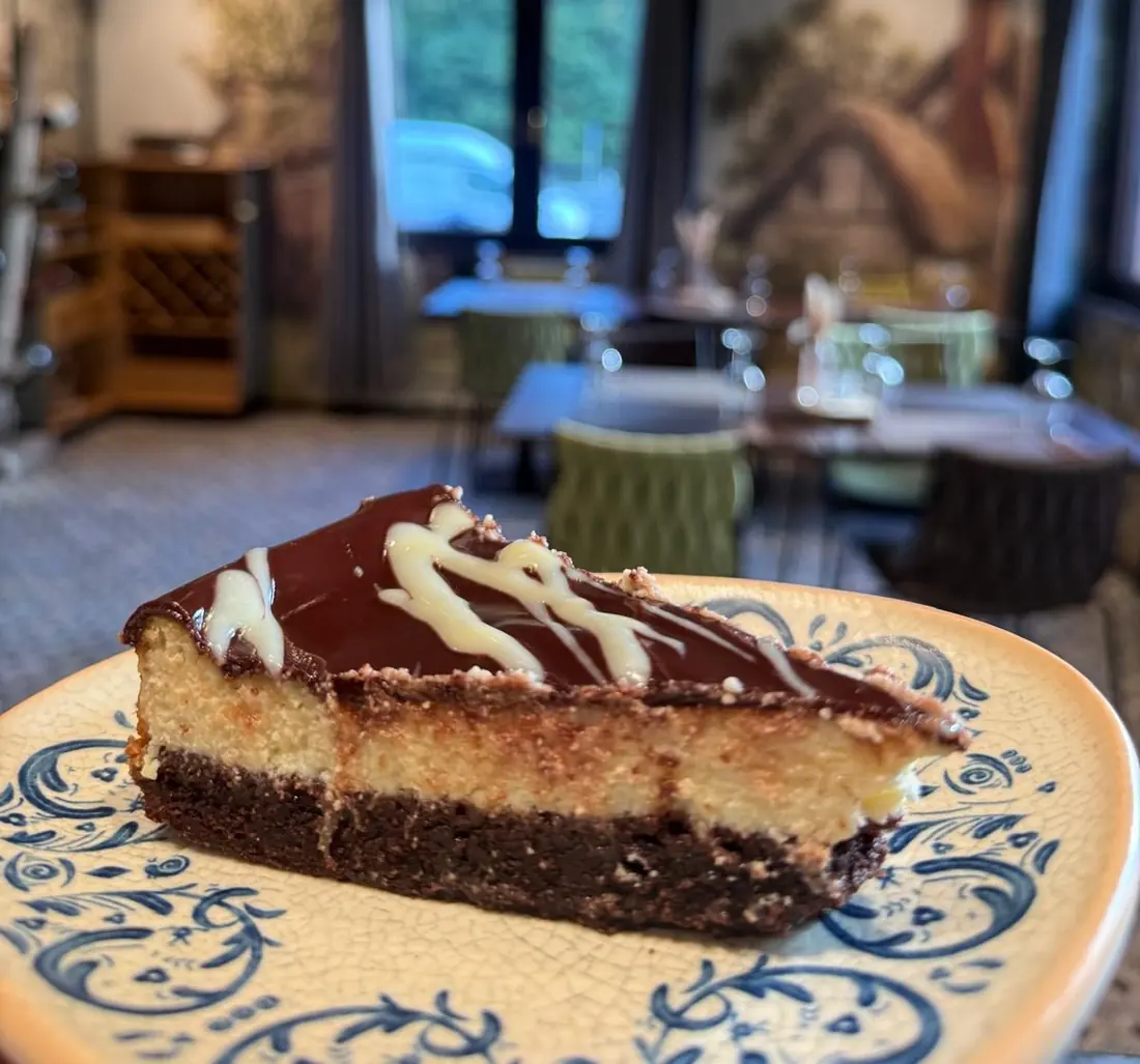 Ein Stück Brownie-Käsekuchen auf blau-weißem Teller