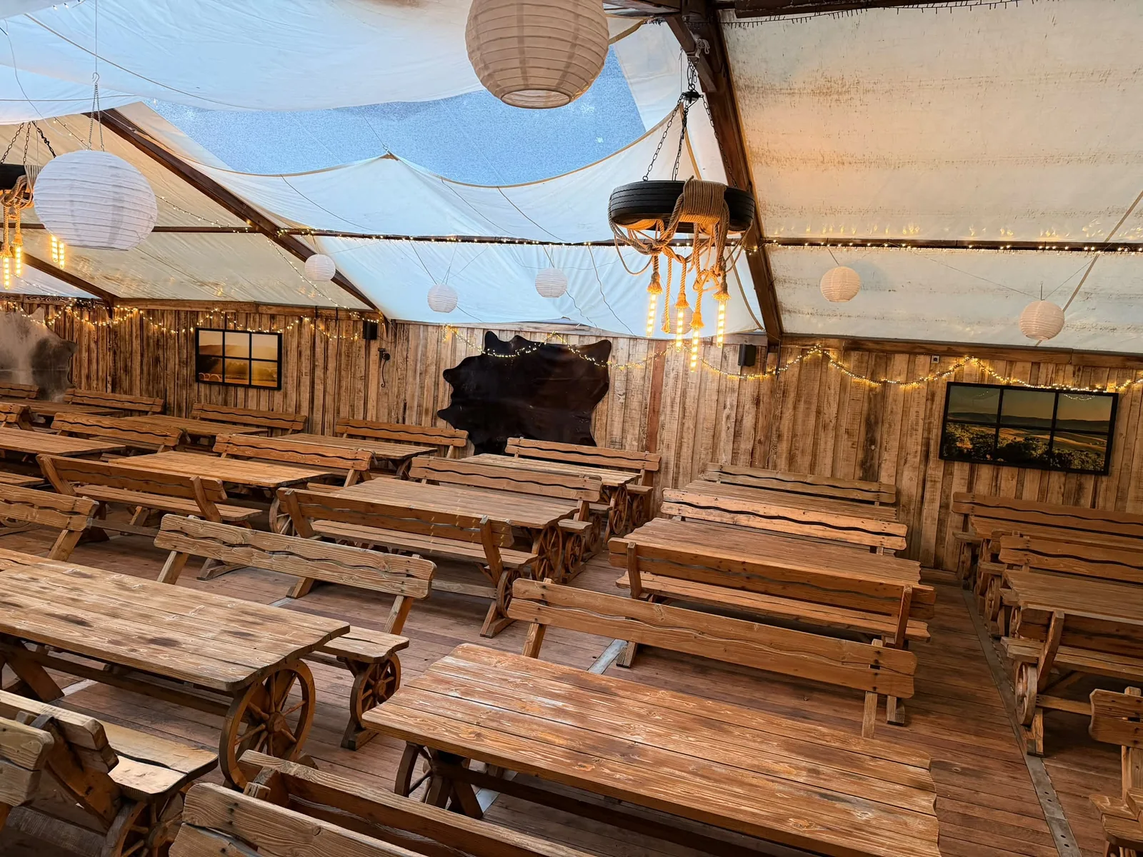 Unser Festzelt mit Holzgarnituren, Lampions, Lichterketten und Leuchtern aus Seil